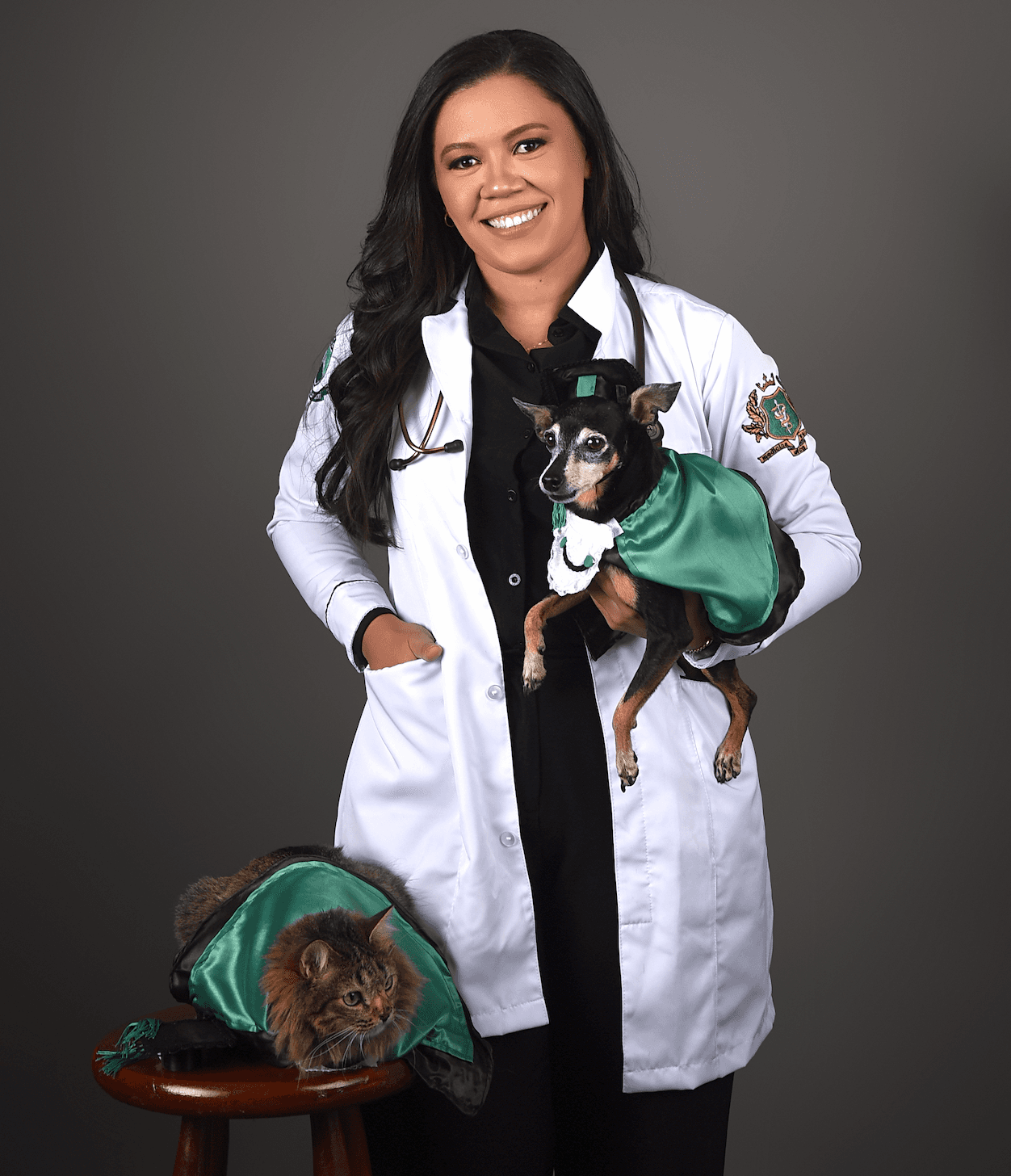 Dra. Luana Bezerra, médica veterinária, segurando um cão e ao lado de um gato