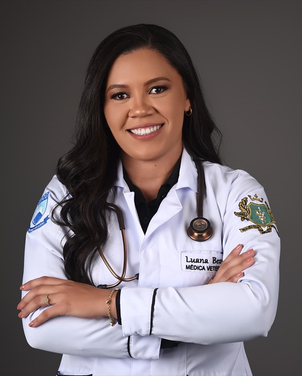Dra. Luana Bezerra de jaleco, com estetoscópio e braços cruzados